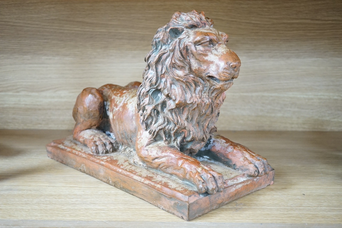 A terracotta sculpture of a lion, 39cm wide. Condition - good